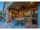 Relaxing covered patio features ceiling fan, outdoor lighting, dining set, and sliding glass doors at 10846 E Quartet Ave, Mesa, AZ 85212