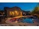Backyard oasis with pool, spa, lounge area, and lush landscaping illuminated at twilight at 10846 E Quartet Ave, Mesa, AZ 85212