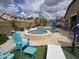 Backyard pool featuring a spa, lounge chairs, an umbrella, and professional landscaping at 10846 E Quartet Ave, Mesa, AZ 85212
