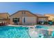 Backyard oasis with a sparkling swimming pool, hot tub, and ample seating areas for relaxation and entertainment at 10846 E Quartet Ave, Mesa, AZ 85212