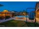 Backyard oasis with pool, spa, lounge area, and lush landscaping illuminated at twilight at 10846 E Quartet Ave, Mesa, AZ 85212