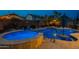 A luxurious pool with a built-in spa, accent lighting, and a serene backyard at twilight at 10846 E Quartet Ave, Mesa, AZ 85212