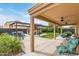 Enjoy the covered patio with ceiling fans and backyard view, including the pergola, spa, and ample seating at 1231 W Beacon Ct, Casa Grande, AZ 85122
