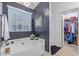 Elegant bathroom featuring a soaking tub under a chandelier, next to a walk-in closet at 1231 W Beacon Ct, Casa Grande, AZ 85122
