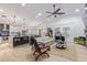 Open-concept living room with a ceiling fan, modern light fixtures, kitchen island, and dining area at 1231 W Beacon Ct, Casa Grande, AZ 85122