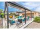 The backyard includes a pergola with roll-down shades, a spa, a patio set, and a lush, low-maintenance landscape at 1231 W Beacon Ct, Casa Grande, AZ 85122