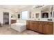 Bright bathroom featuring double sinks, a soaking tub, and classic wood cabinetry at 13932 N 135Th Dr, Surprise, AZ 85379