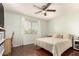 Comfortable bedroom with hardwood floors, a ceiling fan, and natural light from the window at 13932 N 135Th Dr, Surprise, AZ 85379