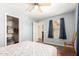 Cozy bedroom with wood-style flooring, a ceiling fan, and natural light from the window at 13932 N 135Th Dr, Surprise, AZ 85379