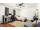 Bedroom featuring hardwood floors, a ceiling fan, dark curtains, and a cozy seating area at 13932 N 135Th Dr, Surprise, AZ 85379