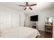 Bedroom with hardwood floors, ceiling fan, desk area, and a sliding door closet at 13932 N 135Th Dr, Surprise, AZ 85379