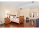 Large main bedroom featuring dark wood floors, two side tables with lamps, and a comfortable queen-sized bed at 13932 N 135Th Dr, Surprise, AZ 85379