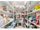 Walk-in pantry with ample white shelving, offering plenty of storage for food and household items at 13932 N 135Th Dr, Surprise, AZ 85379