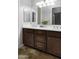Bathroom featuring dual sinks, a mirrored vanity, and decorative plants at 1394 E Grand Canyon Dr, Chandler, AZ 85249