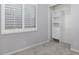 Neutral bedroom with a spacious closet featuring built-in organizers and bright white window shutters at 1394 E Grand Canyon Dr, Chandler, AZ 85249