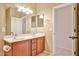 Bright bathroom featuring a double sink vanity, large mirror and tile flooring at 14214 W Ventura St, Surprise, AZ 85379