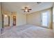 Bedroom with light walls, neutral carpet, ceiling fan and entrance to bathroom and closet at 14214 W Ventura St, Surprise, AZ 85379