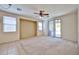 Bright carpeted bedroom with a ceiling fan and sliding glass door to the patio at 14214 W Ventura St, Surprise, AZ 85379