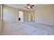 Bedroom with light walls, neutral carpet, ceiling fan and entrance to bathroom at 14214 W Ventura St, Surprise, AZ 85379