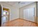 Bedroom with light walls, wood floors, closet, ceiling fan and door to hall at 14214 W Ventura St, Surprise, AZ 85379