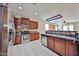 Modern kitchen with stainless steel appliances, dark wood cabinetry, and breakfast bar at 14214 W Ventura St, Surprise, AZ 85379