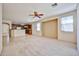 Spacious carpeted living room with a ceiling fan and kitchen access at 14214 W Ventura St, Surprise, AZ 85379
