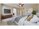 Comfortable primary bedroom with a ceiling fan, attached ensuite bathroom, and neutral decor at 14214 W Ventura St, Surprise, AZ 85379