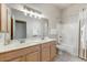 Well-lit bathroom featuring double sinks, vanity and shower with white tile at 15201 N Zapata Dr, Fountain Hills, AZ 85268