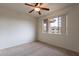 Bright carpeted bedroom features a ceiling fan and large picture window at 16013 S Desert Foothills Pkwy # 2055, Phoenix, AZ 85048