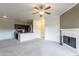 Spacious living room with a fireplace, ceiling fan, and adjoining kitchen, perfect for relaxing and entertaining guests at 16013 S Desert Foothills Pkwy # 2055, Phoenix, AZ 85048