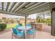 Outdoor kitchen featuring a built-in grill, dining table, and a view of the community's putting green at 16013 S Desert Foothills Pkwy # 2055, Phoenix, AZ 85048
