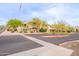 Community street view featuring lush desert landscaping, mature trees, and community signage at 16013 S Desert Foothills Pkwy # 2055, Phoenix, AZ 85048