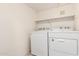 Functional laundry room with appliances, shelf and white walls providing a clean and efficient space at 16616 E Gunsight Dr # 114, Fountain Hills, AZ 85268