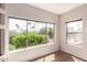 Bright living room featuring a large picture window with lush greenery and palm tree views at 16616 E Gunsight Dr # 114, Fountain Hills, AZ 85268