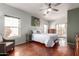Well-lit bedroom with hardwood floors, neutral paint, a ceiling fan, and balcony access at 16616 E Gunsight Dr # 114, Fountain Hills, AZ 85268