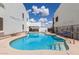 Sparkling community pool surrounded by white buildings under a blue sky with fluffy clouds at 16616 E Gunsight Dr # 114, Fountain Hills, AZ 85268