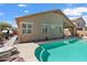 Back exterior view of the house with a pool, patio and desert landscaping at 16876 W Stevenage St, Surprise, AZ 85374