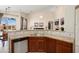 Eat-in kitchen with wood cabinets, granite countertops, and a stainless steel dishwasher at 16876 W Stevenage St, Surprise, AZ 85374