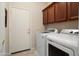 Laundry room features a modern washer and dryer and extra storage space at 16876 W Stevenage St, Surprise, AZ 85374