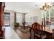 Bright living and dining space featuring tiled floors, plantation shutters, and dining table at 16876 W Stevenage St, Surprise, AZ 85374