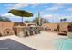 Covered outdoor bar area with seating, desert plants, and a stucco privacy wall, perfect for entertaining at 16876 W Stevenage St, Surprise, AZ 85374