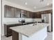 Modern kitchen featuring stainless steel appliances, dark cabinetry, and a spacious center island with a granite countertop at 18007 W Camino De Oro --, Surprise, AZ 85387