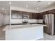 Modern kitchen featuring stainless steel appliances, dark cabinetry, granite countertops and a spacious center island at 18007 W Camino De Oro --, Surprise, AZ 85387