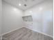 Clean and simple laundry room featuring wood-look tile flooring, utility connections, and overhead shelving at 18007 W Camino De Oro --, Surprise, AZ 85387
