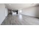 Expansive living space showcasing wood-look tile floors and a view of kitchen and laundry room at 18007 W Camino De Oro --, Surprise, AZ 85387