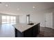 Open-concept living room and kitchen area with wood-look tile flooring and a view of the backyard through sliding glass doors at 18007 W Camino De Oro --, Surprise, AZ 85387