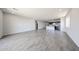 Open-concept living space with wood-look tile flooring and view into the kitchen with stainless appliances at 18007 W Camino De Oro --, Surprise, AZ 85387