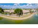 Aerial view of a charming lakeside property with mature trees, lush landscaping, and a fenced backyard at 1806 N 108Th Ave, Avondale, AZ 85392