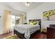Bright bedroom with a queen size bed, a ceiling fan, a view of the lake, and hardwood floors at 1806 N 108Th Ave, Avondale, AZ 85392