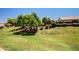 Scenic common area featuring a grassy hill, mature trees, and well-maintained landscaping for community enjoyment at 1806 N 108Th Ave, Avondale, AZ 85392